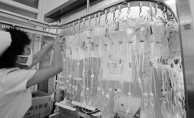 2006年6月22日,北京儿童医院注射室护士正忙着为患病儿童进行吊瓶