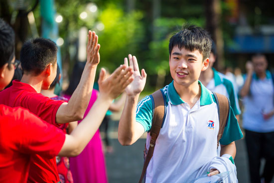 考生即将进入考场前,教师为学生加油打气,相互击掌拥抱.视觉中国供图