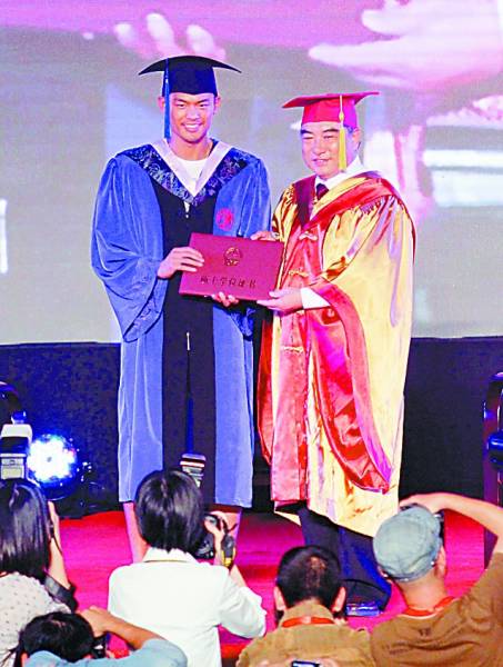 10月17日,林丹(左)从华侨大学校长手中接过硕士学位证书